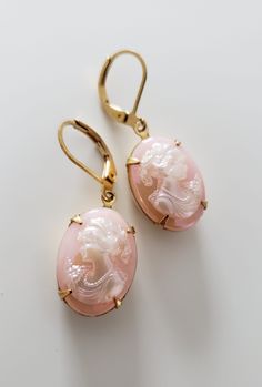 Rose engraved crystals with hidden design. Embedded in a polished gold frame. Luxury Vintage Pink Earrings, Elegant Oval Engraved Earrings, Gold-tone Oval Elegant Jewelry, Elegant Oval Gold-tone Jewelry, Elegant Pink Jewelry For Evening, Elegant Pink Evening Jewelry, Elegant Gold Cameo Earrings, Elegant Cameo Jewelry For Anniversary, Antique Pink Jewelry For Formal Occasions