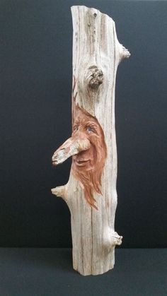 a wooden carving of a dog with its head on a tree branch, which has been carved into the bark