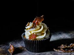 a cupcake sitting on top of a wooden table next to some dried fruit and nuts