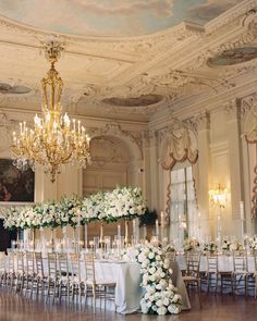 an elegant ballroom with chandeliers and white flowers