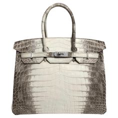 Up for sale is the Holy Grail Hermès Birkin 35 Diamond Himalayan. The Diamond Himalyan is the pinnacle of luxury and elegance, celebrated as one of the rarest and most exquisite handbags in the world. Crafted from Niloticus crocodile leather, the bag features a color gradient that ranges from a rich smoky gray to a pearly white, reminiscent of the majestic Himalayas, which inspired its name. What elevates this Birkin to a level of pure opulence is the dazzling hardware: the clasp, lock, and key are crafted from 18-karat white gold, and are adorned with sparkling, flawless diamonds. The combination of radiant diamonds set against the refined gradient of the leather makes this handbag a true masterpiece. With only a few pieces made every year the Diamond Himalayan Birkin is more than just a Hermes Birkin Himalayan Diamond, Most Expensive Hermes Bag, Hermes Ostrich Birkin, Hermes Himalayan, Himalayan Birkin, Rich Bags, Hermes Crocodile Bag, Birken Bag, Status Symbol