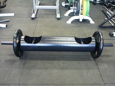 a barbell bench in the middle of a gym with several different types of exercise equipment