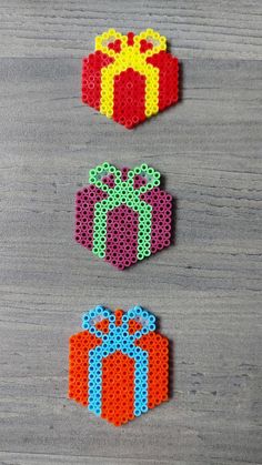 three pieces of perler bead art with bows and gift boxes on the side