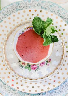 a plate with a strawberry and mint garnish on it