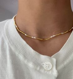 Dainty and delicate, this gold beaded choker necklace is our new favorite. This delicate choker features tiny gold beads and adorned with a mix of fresh water small pearls. It's full of beach vibes. Wear this beaded choker alone or layer a few of our bolder necklaces. 18k gold plated Brass base Fresh water pearls 3 lengths: 15.5"; 16.5"; 17.3" Trendy Gold Pearl Choker, Trendy Gold Pearl Choker Necklace, Dainty Gold Pearl Necklace With Gold Beads, Trendy Gold Pearl Beaded Necklaces, Gold Choker With Round Beads For Summer, Gold Round Beads Choker For Summer, Everyday Gold Pearl Necklace With Tiny Beads, Summer Gold Pearl Necklace, Trendy Gold Beaded Necklace For Everyday