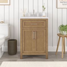 a white toilet sitting next to a wooden cabinet