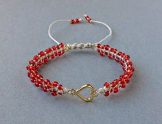 Red Seed Bead Heart Bracelet, Valentines Day Bracelet, Tiny Macrame Bracelet, Gift For Her The Bracelet is made by me with seed beads in red color, gold tone metal heart and light grey synthetic satin cord. ❥It is perfect as a gift to a friend or someone you love. SIZES: --------- Metal heart: 15 mm x 9 mm Width of Bracelet: 6 mm Synthetic Satin Cord: 0.9 mm Seed Beads: 2 mm Adjustable size in length with a sliding spiral macrame knot. Expands from 15 to 26 cm. Let me know if you need a differen Macrame Knot, Metal Heart, Macrame Bracelets, Heart Bracelet, Gold Tone Metal, Infinity Bracelet, Friendship Bracelets, Seed Beads, Gold Tones