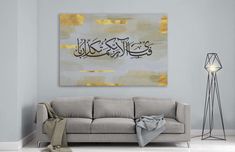 a living room with a couch, lamp and painting on the wall in arabic script