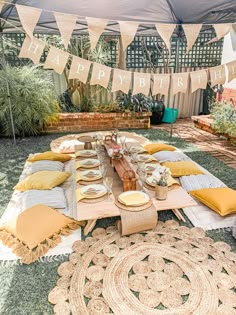 a table set up with plates and place settings for an outdoor birthday party or celebration