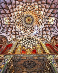 the inside of an ornate building with many windows and ceiling tiles on it's walls