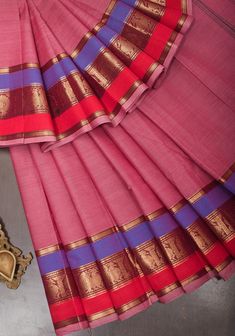 It is said that when weaving practices first began at Kanchipuram centuries back, the weavers used cotton as their primary base. Even though the Kanjivaram silk has taken predominance, the cotton sarees of this town have stood the test of time and have gained popularity. This all natural Kanchi cotton saree in an eye-pleasing color contrast carries the sophisticated charm that is attributed to sarees made in the looms of Kanjivaram. The wide border decorated with traditional motifs in zari enhan Kanchi Cotton Saree, Cotton Sarees Online, Strawberry Pink, Traditional Motifs, Cotton Sarees, Color Contrast, Social Events, Yellow And Brown, Sarees Online