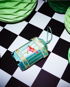 an origami bag sitting on top of a checkered black and white floor