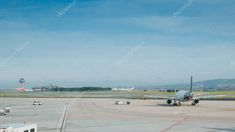 an airplane sitting on the tarmac at an airport with other planes in the background