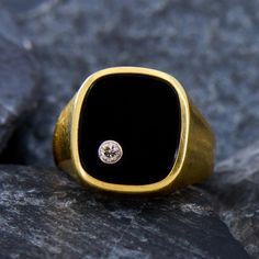 This smooth men's ring has a cushion cut onyx tablet face, set with a bezel-set round brilliant cut diamond in the one of the corners. The ring has a very midcentury modern feel to the design. It is crafted in 14k yellow gold and is currently a size 11.75. Modern Diamond Signet Ring, Luxury Signet Ring With Smooth Bezel For Formal Occasions, Luxury Smooth Bezel Signet Ring For Formal Events, Modern Formal Signet Ring With Single Diamond, Modern Black Enamel Rings For Formal Occasions, Modern Black Enamel Signet Ring For Anniversary, Classic Black Enamel Signet Ring For Formal Occasions, Modern Black Enamel Rings For Formal Events, Formal Black Ring With Single Diamond