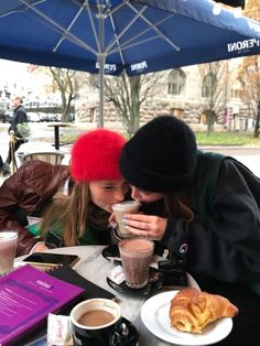 two women sitting at a table drinking coffee