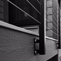 a black and white photo of the side of a house with metal bars on it