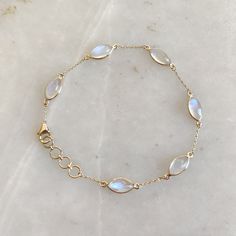 "ITEM DESCRIPTION: >> The bracelet is made from Solid 14K Yellow Gold. Gemstone used is absolutely natural and ethically sourced.  >> Natural Rainbow Moonstones cabochons and marquise shape with bezel setting is studded on it with utmost precision.  >> This is a minimalist design and is absolutely hassle-free and everyday jewelry.  ✓ Gem: Rainbow Moonstone ✓ Gem size & Shape: 5x10 mm (6 pcs) & marquis  ✓ Gem weight: 7.98 carats ✓ Bracelet Length: 7\" Inches + 0.5\" Inch Adjustable ✓ Gold purity: 14K (58.33% approx.) ✓ Gold weight: 1.57 grams  ✓ Gross weight: 3.17 grams The Gold purity is guaranteed and it comes with authentic 14K gold hallmark. Since these Bracelets are handmade, they are Nickel/Lead FREE.  CUSTOMISATION: --> The same design can be made in varying lengths of your choice. - Gold Moonstone Round Bracelets, Gold Moonstone Gemstone Bracelets, Gold Moonstone Bracelet With Gemstones, Elegant Moonstone Gemstone Bracelets, Elegant Moonstone Gemstone Bracelet, Gold Moonstone Bracelet, Dainty Round Moonstone Bracelets, Elegant Round Moonstone Crystal Bracelet, Handmade Jewelry Box