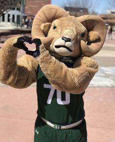 a mascot in a basketball uniform is holding his hands up to the side with one hand