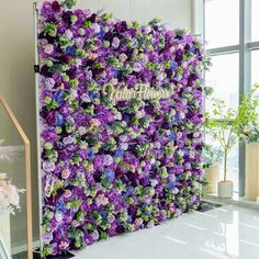 purple and green flowers are growing on the side of a wall in an office building