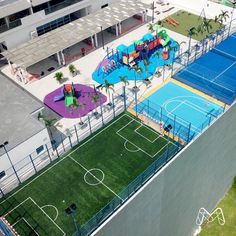 an aerial view of a children's playground and basketball court in front of a building