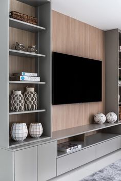 an entertainment center with bookshelves, shelves and a flat screen tv on the wall