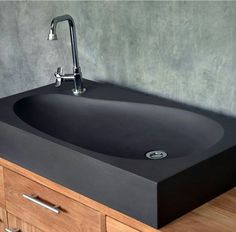 a bathroom sink sitting on top of a wooden counter next to a wall mounted faucet