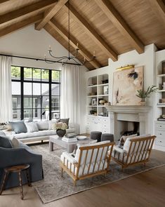 a living room filled with furniture and a fire place in front of a large window