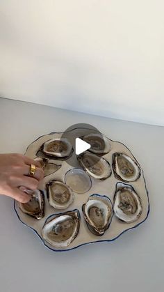 a person is placing oysters on a platter