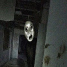 a creepy looking face is seen in the dark