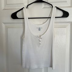 White Brandy Melville Bottom Up Tank, Never Worn, One Size Brandy Melville White Tank Top, White Brandy Melville Top, Casual Cotton Tank Top With Buttons, White Cotton Tank Top With Buttons, White Cotton Buttoned Tank Top, Casual Cotton Tank Top With Button Closure, Casual White Buttoned Tank Top, White Cotton Tank Top With Button Closure, Tops Brandy Melville