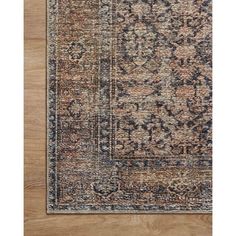 an area rug that is on top of a wooden floor with a blue and brown color scheme