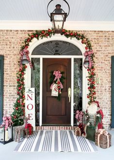 a front porch decorated for christmas with wreaths and decorations