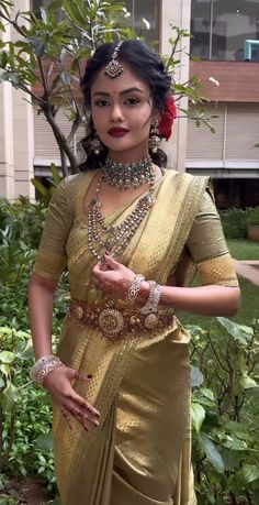 a woman in a sari is posing for the camera with her hand on her hip