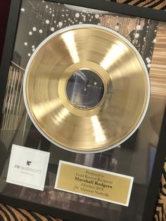 a gold record is on display in a glass case with a black border around it