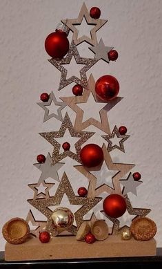 a christmas tree made out of wooden stars and baubles with ornaments on top