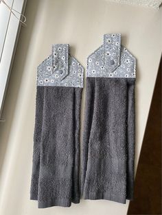 two gray towels hanging on the wall