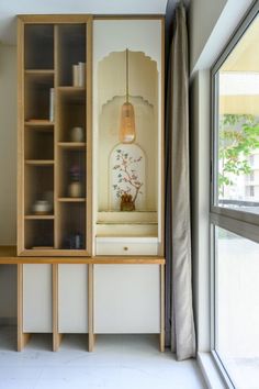 a room with a bookcase, window and vase on the shelf next to it