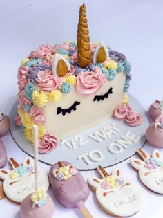 there is a cake with unicorns on it and other decorations around it, including marshmallows