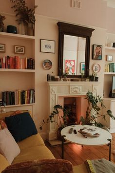 a living room filled with furniture and a fire place next to a book shelf full of books