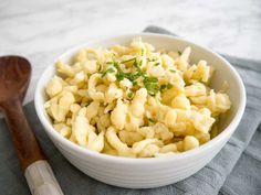 a white bowl filled with macaroni and cheese on top of a gray towel