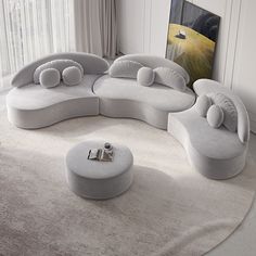 a living room filled with white furniture on top of a carpeted floor next to a window