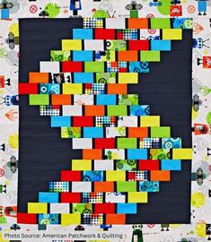 a quilted wall hanging with colorful blocks on it