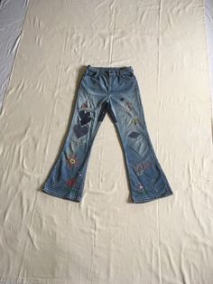 "1960s patched bell bottom blue jeans Wrangler, cotton denim Lightning zipper 4 pockets patches and embroidery authentic age wear w/holes/fray, soft, worn in measures, lying flat, waist-14 1/2\" rise-11 1/2\" inseam-29\" hem-10 1/2\" hip-20\" outseam-40 1/2\"" Bohemian Medium Wash Cotton Flare Jeans, Bohemian Flare Jeans In Medium Wash, Bohemian Medium Wash Flare Jeans, Hippie Style Denim Flare Jeans For Festivals, Cotton Hippie Flare Jeans For Festivals, Retro Embroidered Denim Bottoms, Retro Cotton Jeans For Festivals, Vintage Wide Leg Patchwork Jeans, Vintage Medium Wash Bottoms For Festival