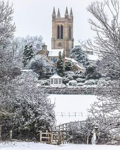 a church in the middle of winter with snow on the ground and trees around it