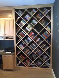 a book shelf with many books on it in a room next to a computer desk