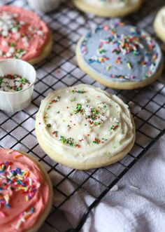 some cookies with sprinkles and frosting on a cooling rack