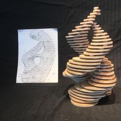 a stack of wooden discs sitting next to a piece of paper on top of a table