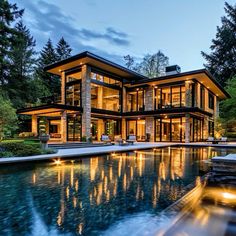 a large house with a pool in front of it and trees around the outside area