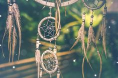 an image of dream catchers hanging from the ceiling in front of trees and snow