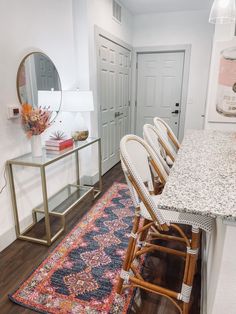 a dining room table and chairs with a rug on the floor